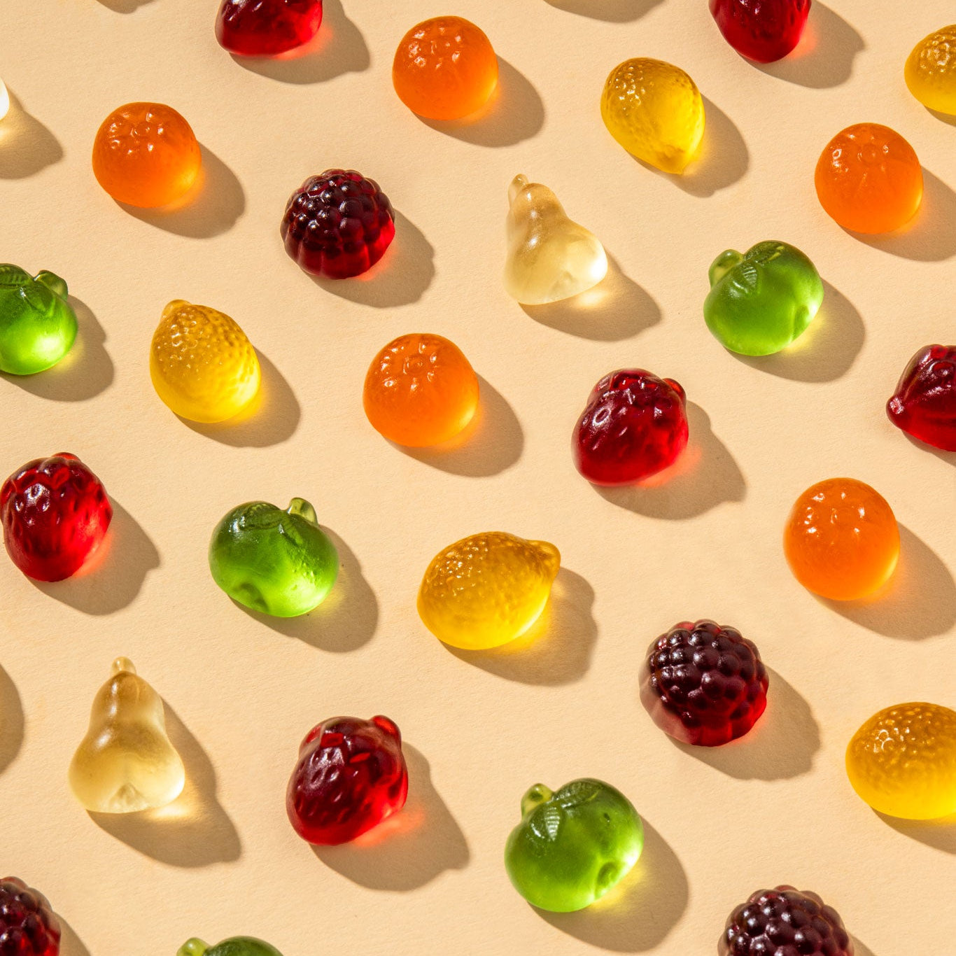 Einzelne Favorite Fruit Bio-Fruchtgummi in angeordnet auf einem beigen Grund mit Schattenspielen.
