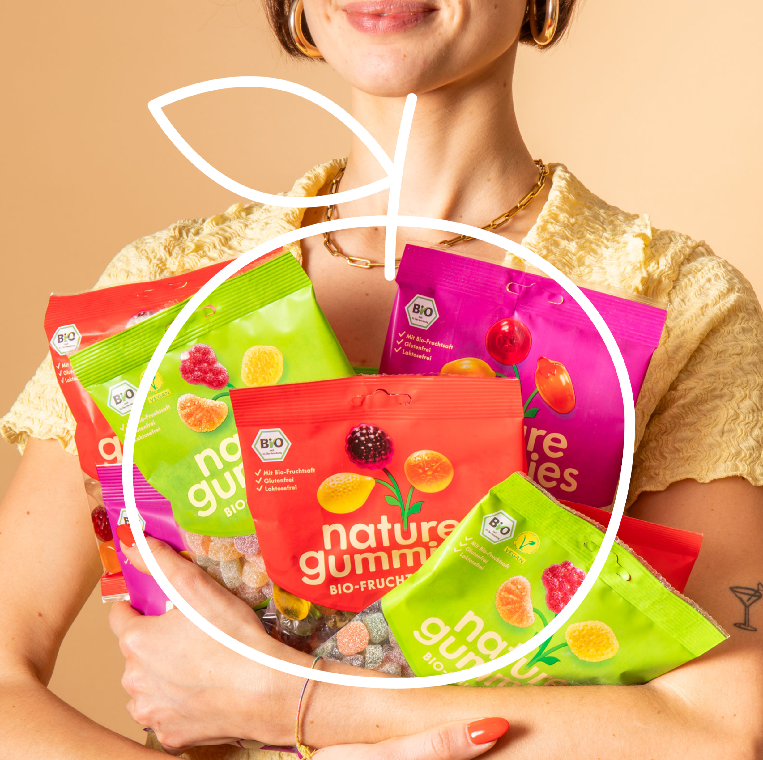 Eine Frau hält sehr viele nature gummies in den Händen und kann sie kaum halten. Sie lächelt dabei und freut sich darüber, dass sie so viele nature gummies genießen kann.